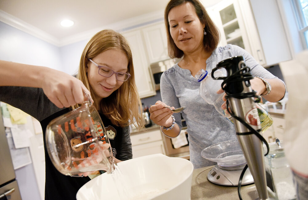 ERICA MILLER/GAZETTE PHOTOGRAPHER  
Zuzana Lundeen and her daughter Emma, 12-years-old, help mix the ingredients for their traditional Slovakian Oplatki, or Kaledaiciai in Polish, for Christmas season in their home in Saratoga Springs, on Sunday, October 28, 2018.